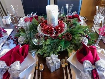Christmas dining table centerpiece with greenery and red accents